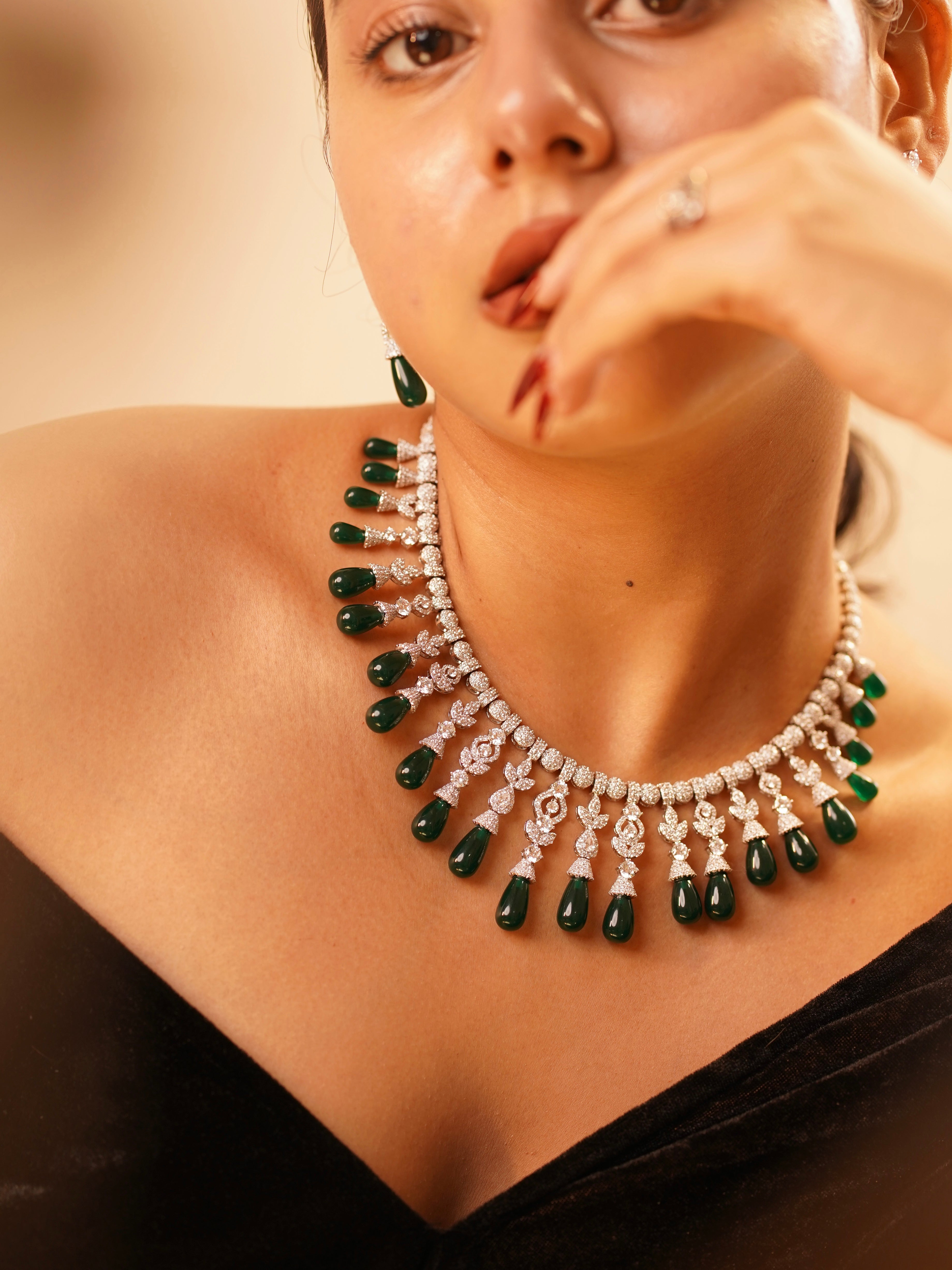 Side profile of emerald statement necklace with brilliant stonework and matching earrings